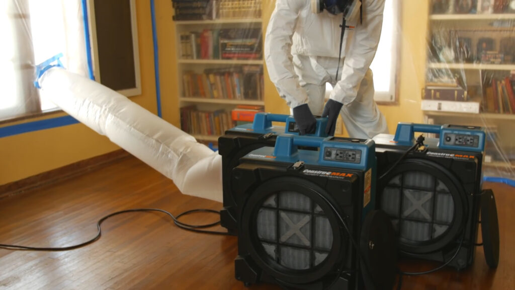 Employee setting up air scrubbers.