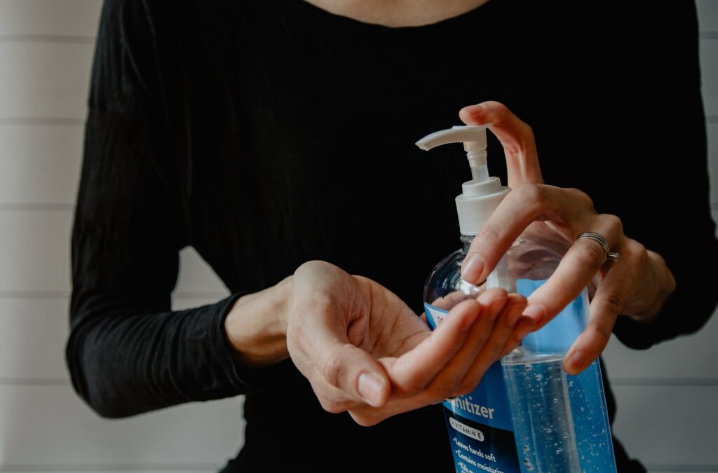 Woman with hand sanitizer, applying it to her hands.