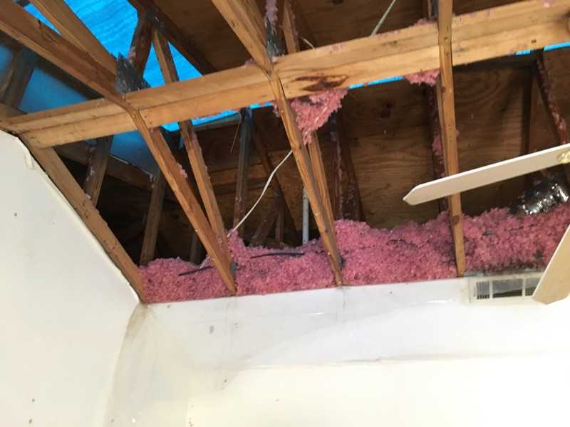 Looking up through the rafters to see the damaged roof from inside