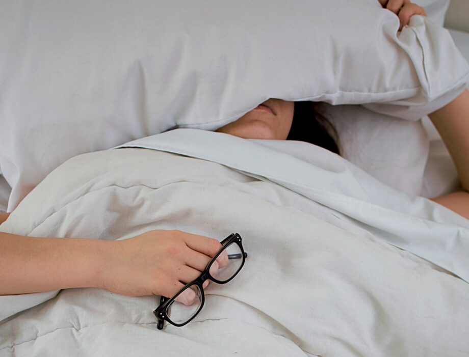 A woman laying sick in bed.