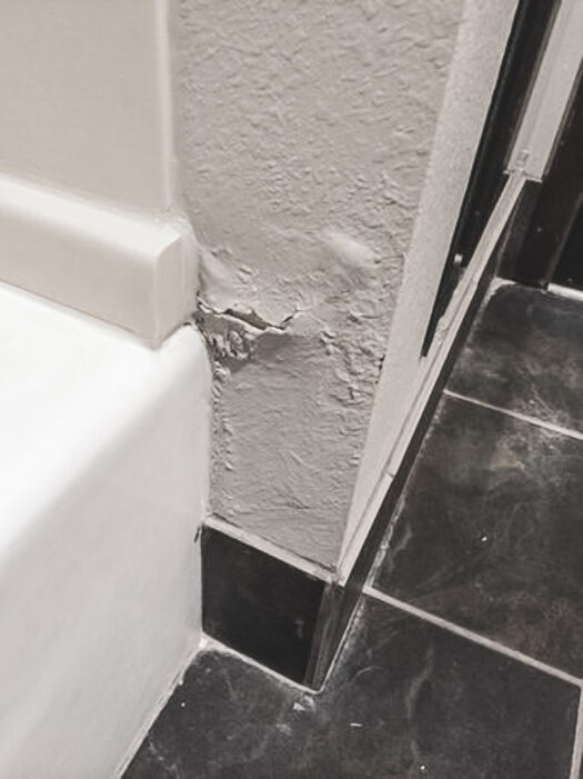 Water damage on the wall outside a tub
