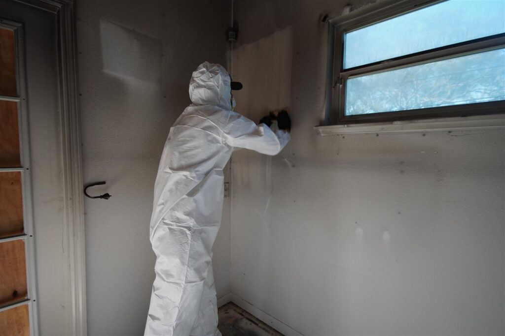 Worker cleaning soot off of walls