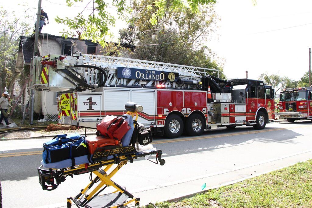 Fire truck parked in front of a burned home