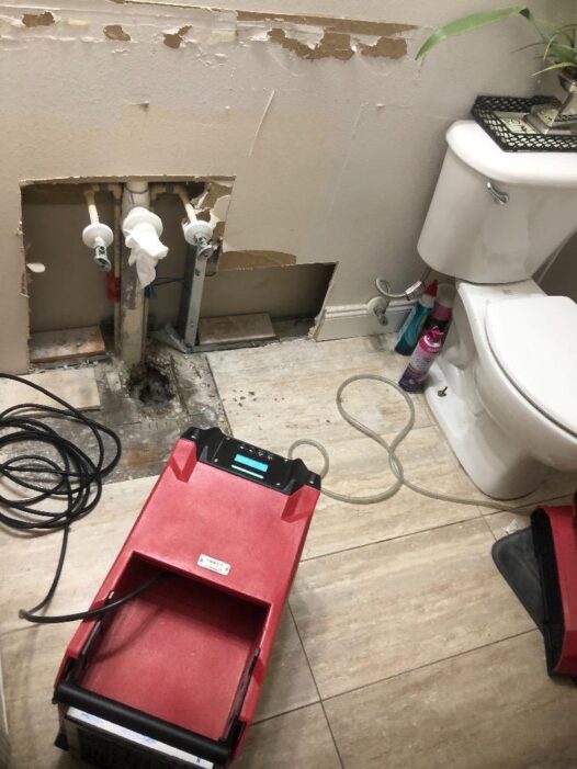 A dehumidifier is placed in a bathroom after a sink had a leak